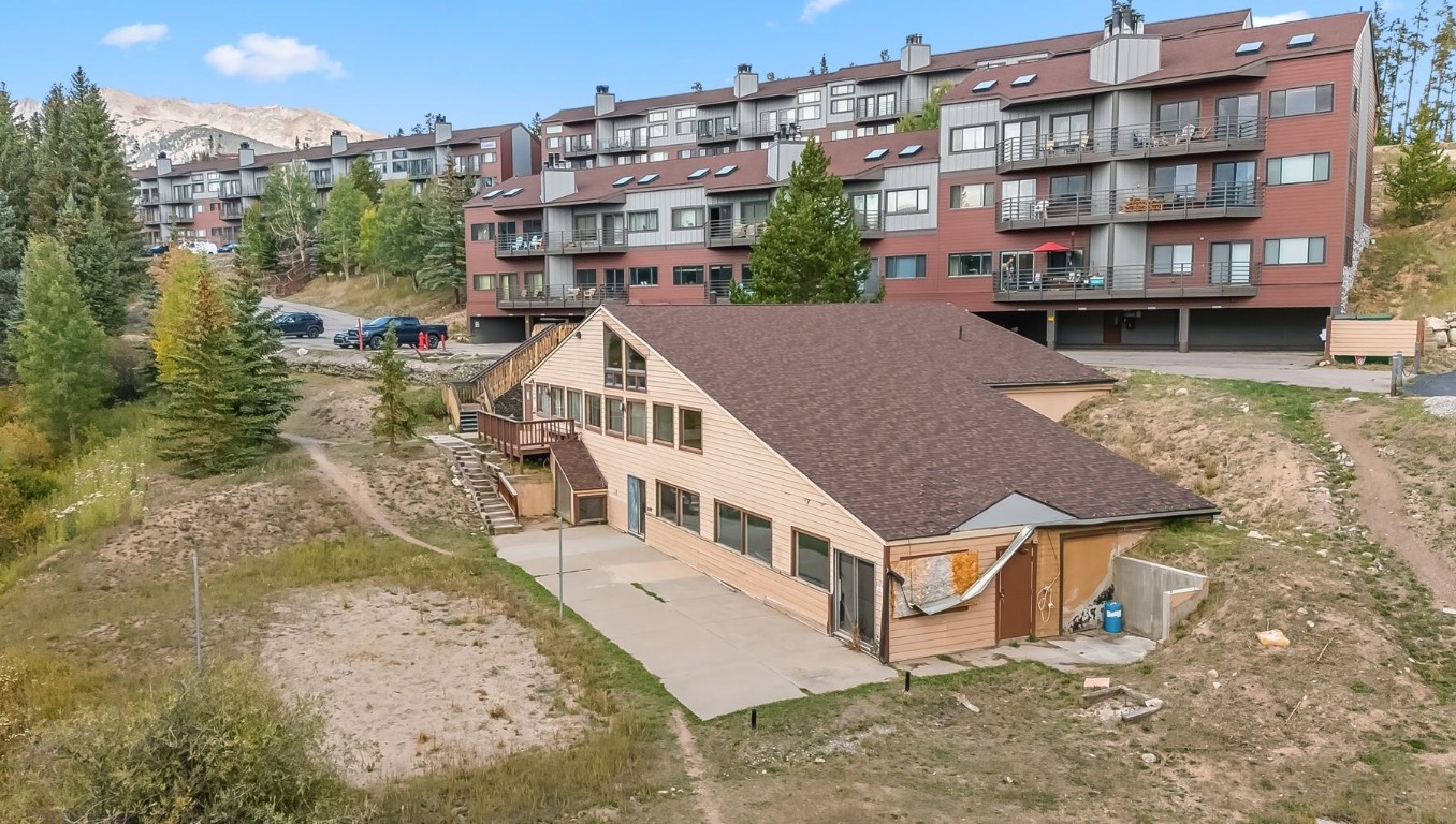9849 Ryan Gulch Road, Unit 203 Silverthorne, CO 80498 - Photo 26 of 35 a house with tall trees in front of it