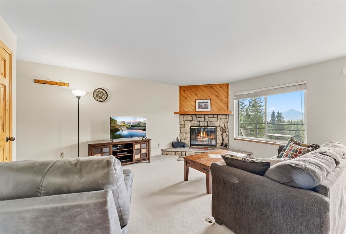 9849 Ryan Gulch Road, Unit 203 Silverthorne, CO 80498 - Photo 8 of 35 a living room with furniture window and a fireplace