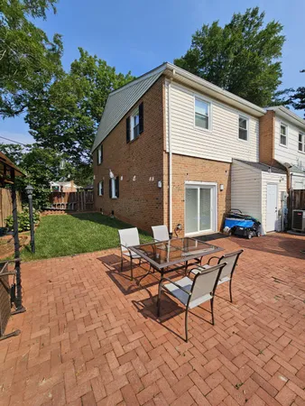 a view of a house with backyard and sitting area