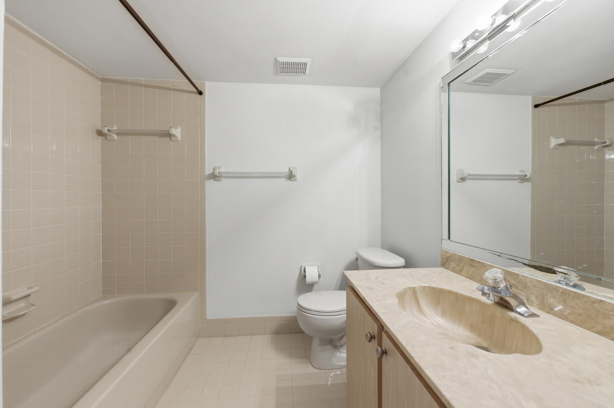 9633 Riverside Drive, Unit E3 Coral Springs, FL 33071 - Photo 19 of 31 a bathroom with a granite countertop sink a toilet and shower