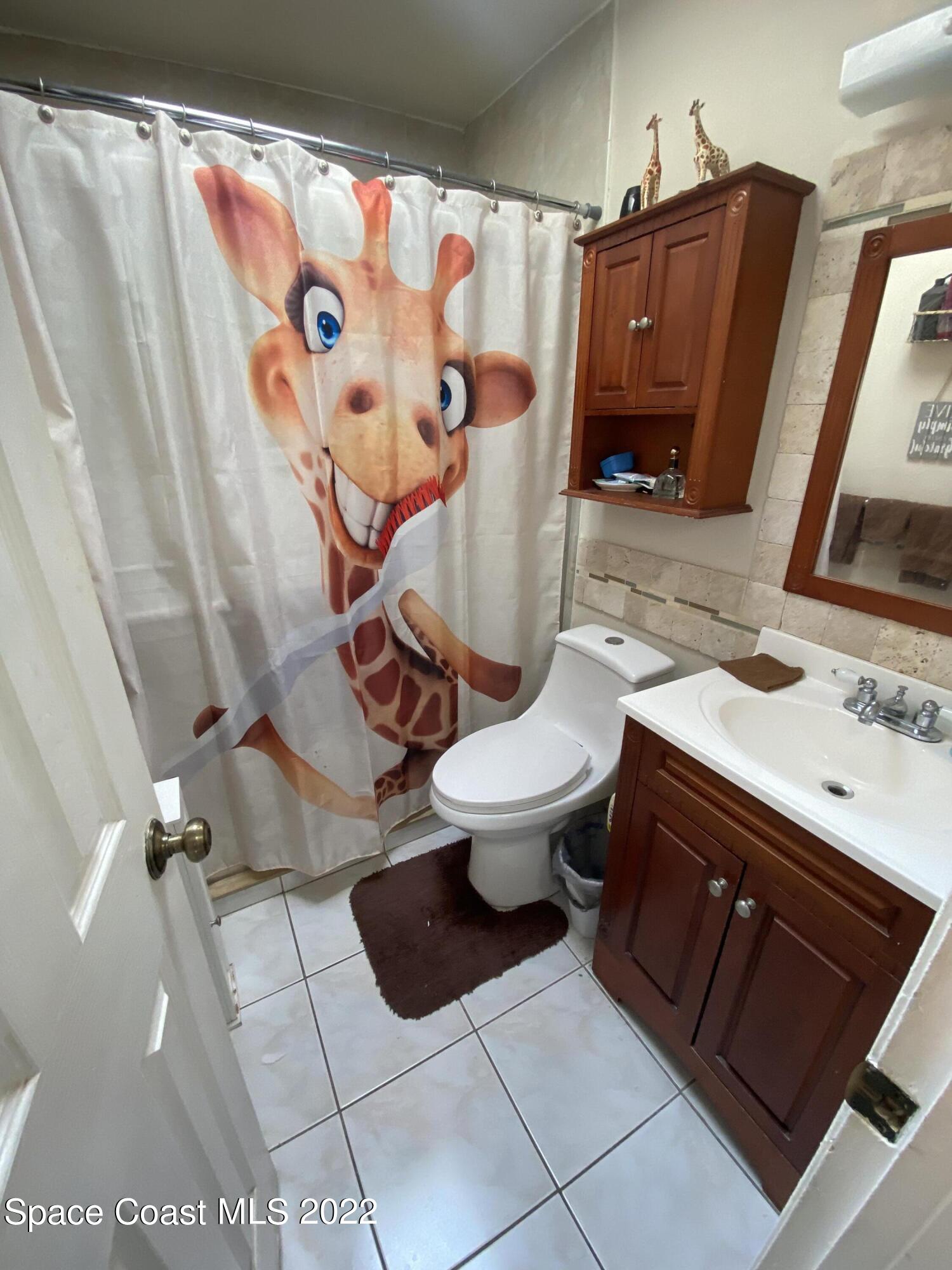 2807 Tropic Road Melbourne, FL 32935 - Photo 12 of 24 a bathroom with a sink toilet and shower