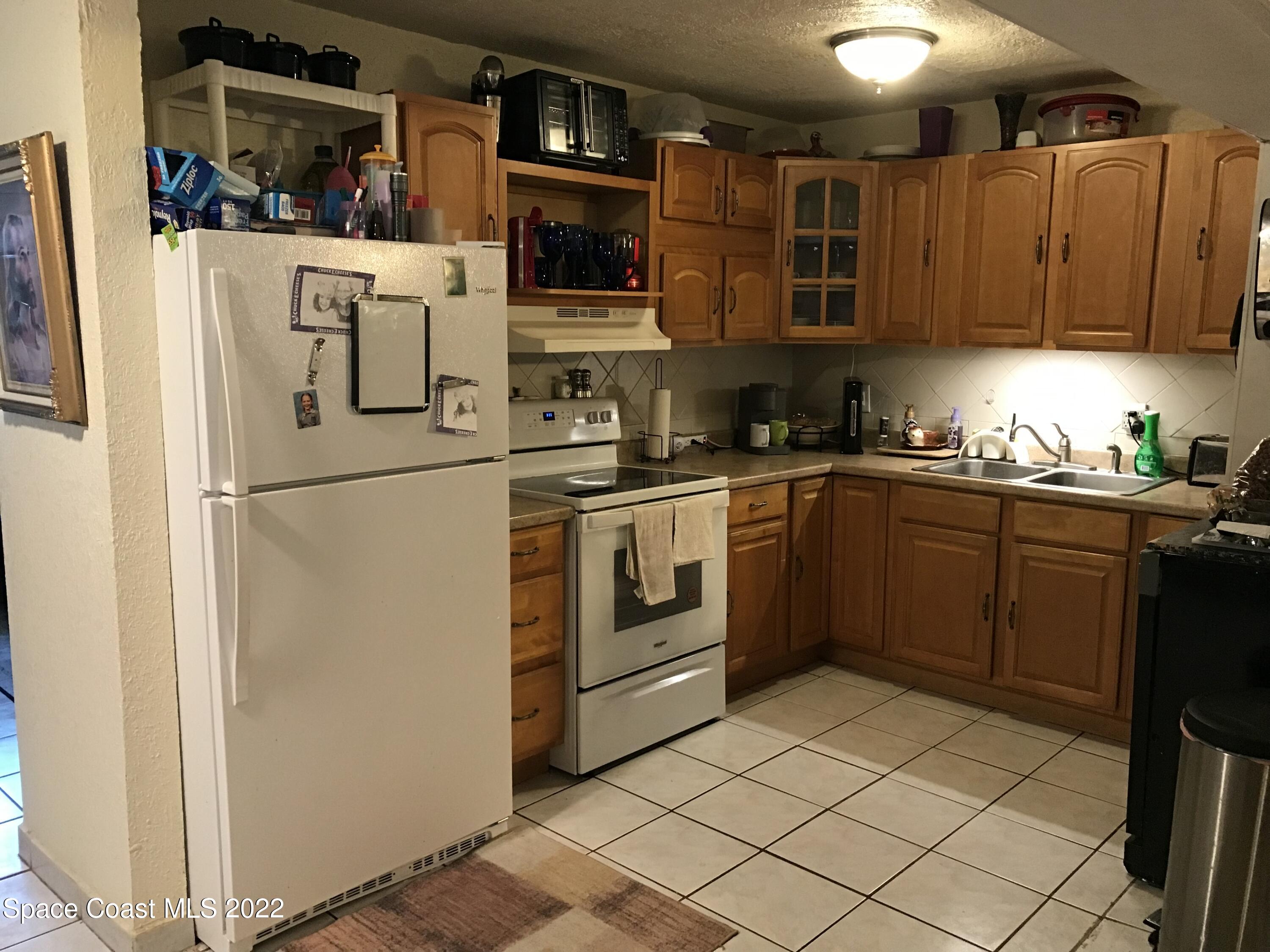 2807 Tropic Road Melbourne, FL 32935 - Photo 2 of 24 a kitchen with stainless steel appliances granite countertop a refrigerator and a stove top oven
