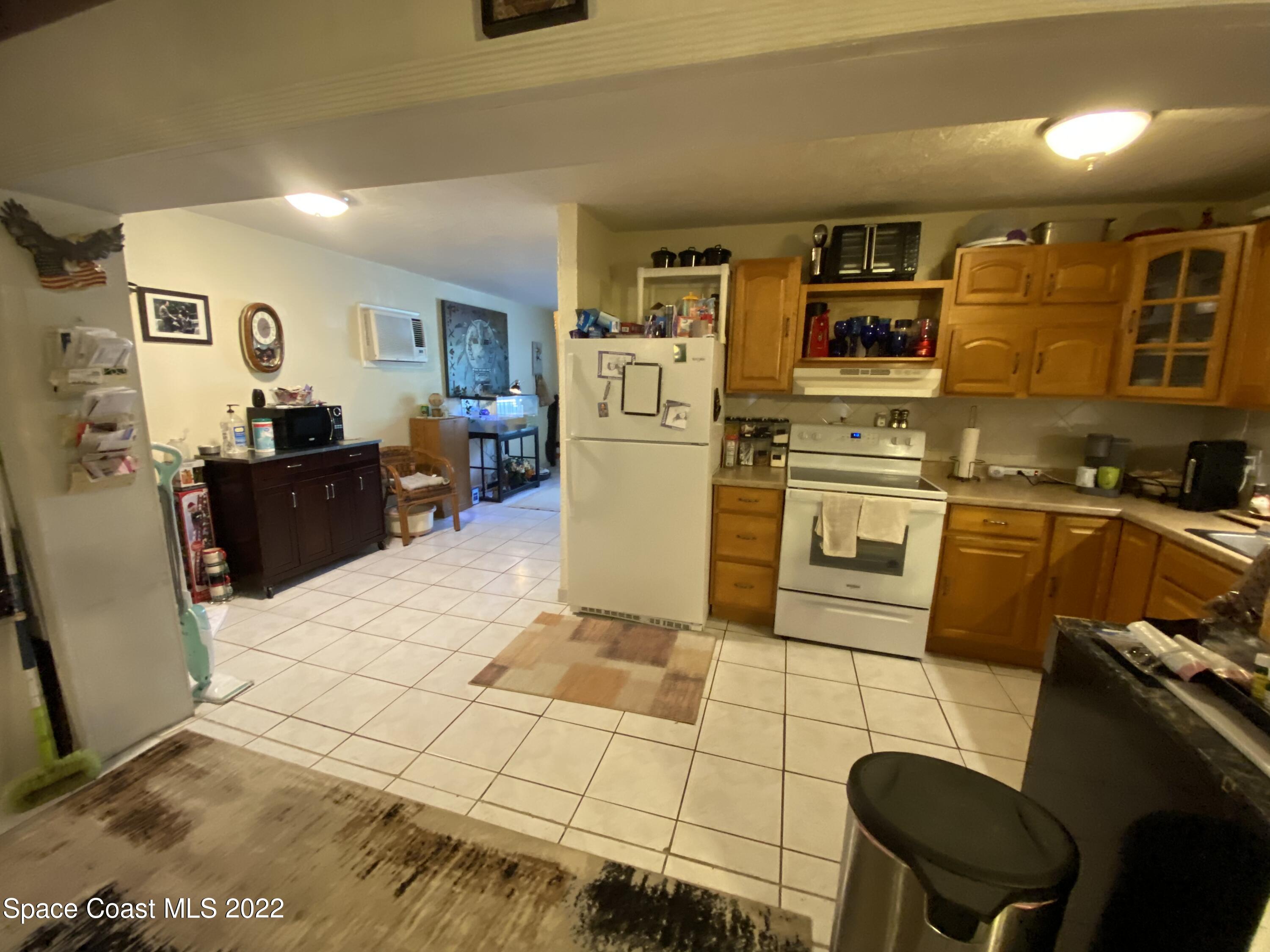 2807 Tropic Road Melbourne, FL 32935 - Photo 5 of 24 a kitchen with stainless steel appliances kitchen island granite countertop a refrigerator and stove