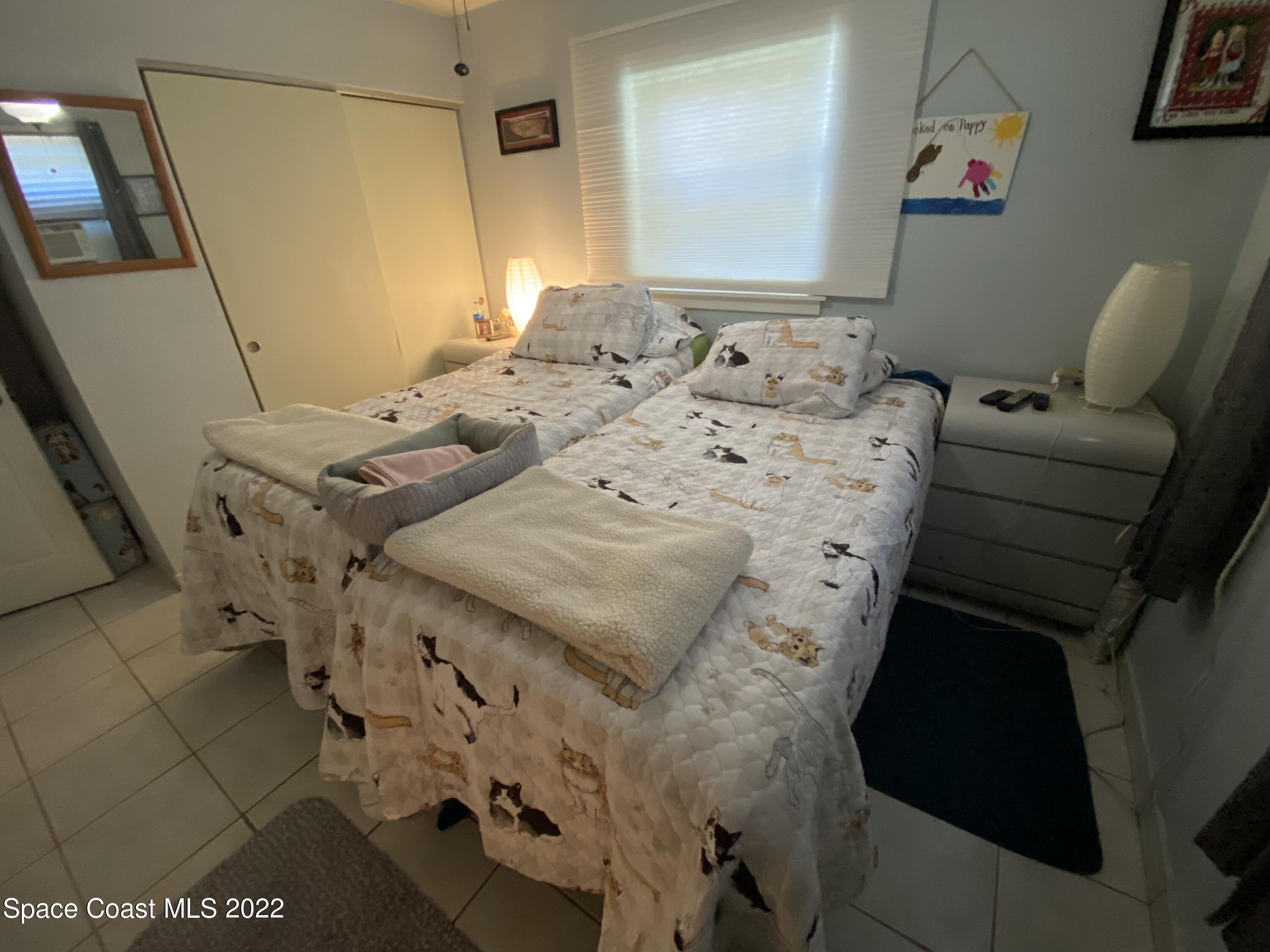 2807 Tropic Road Melbourne, FL 32935 - Photo 8 of 24 a bed sitting in a bedroom next to a window