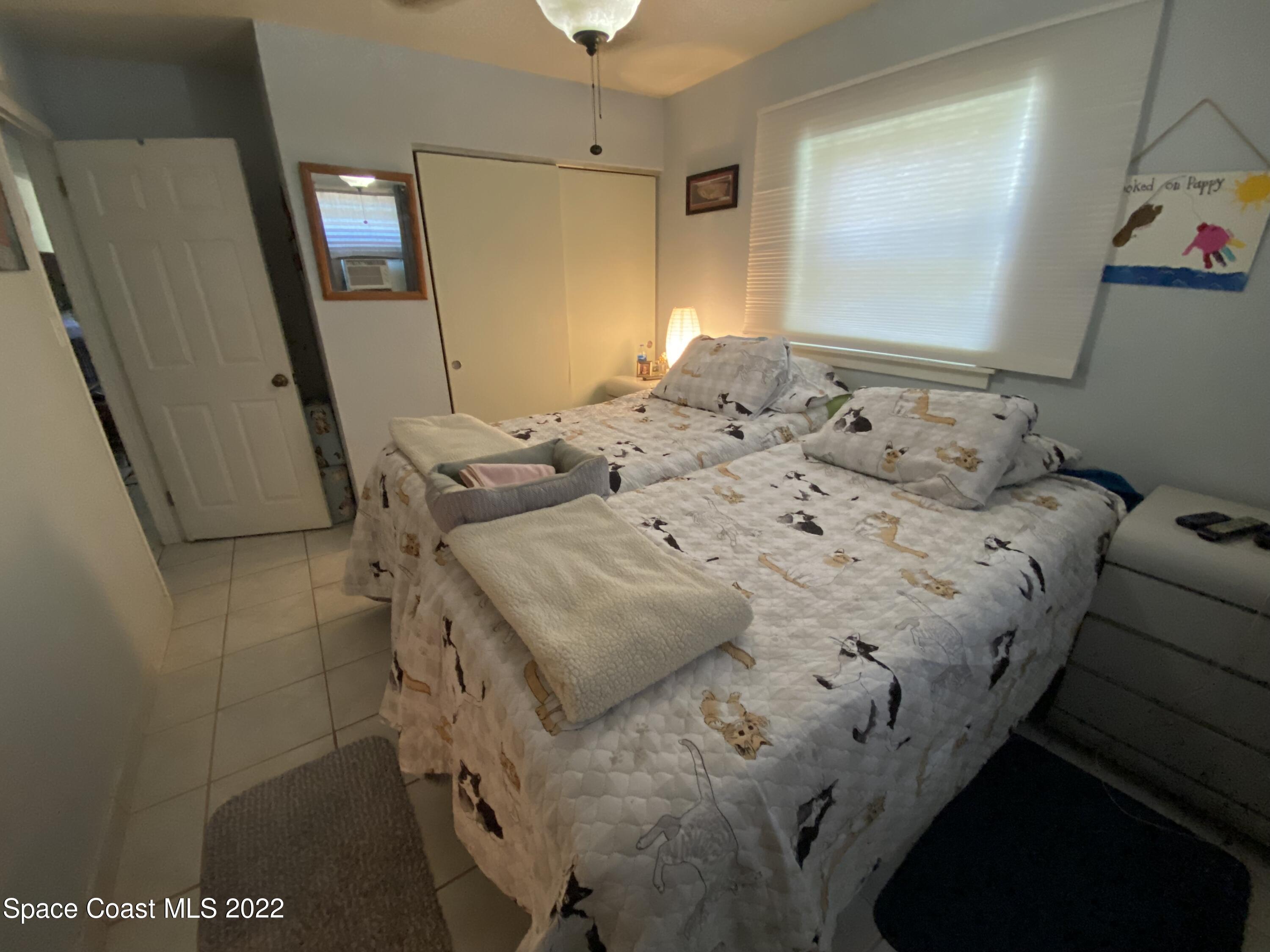 2807 Tropic Road Melbourne, FL 32935 - Photo 9 of 24 a bedroom with a bed and a mirror