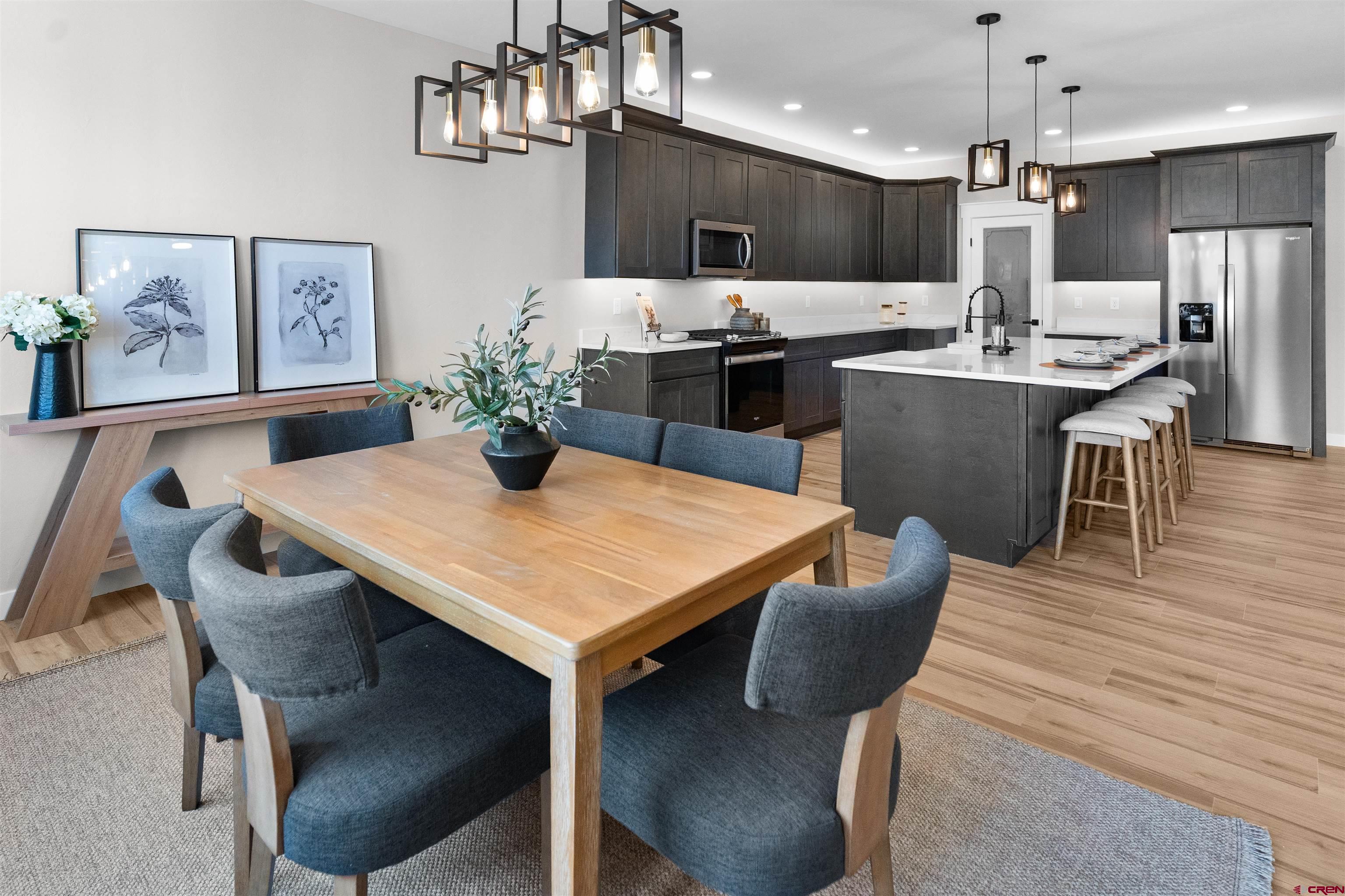 1539 Criterion Street Delta, CO 81416 - Photo 15 of 41 a kitchen with stainless steel appliances kitchen island granite countertop a kitchen island a stove a dining table and chairs