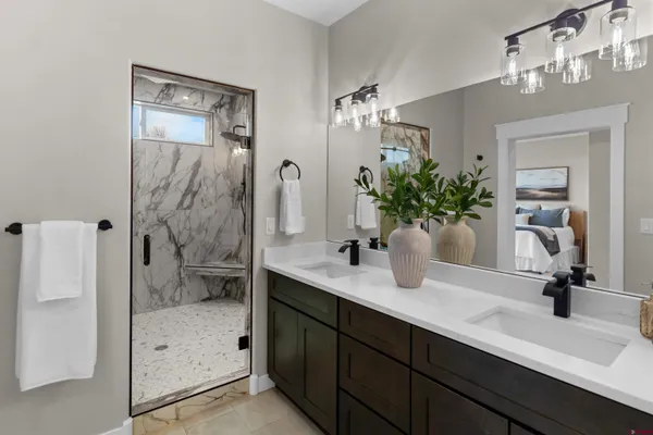 a bathroom with a double vanity sink mirror and shower