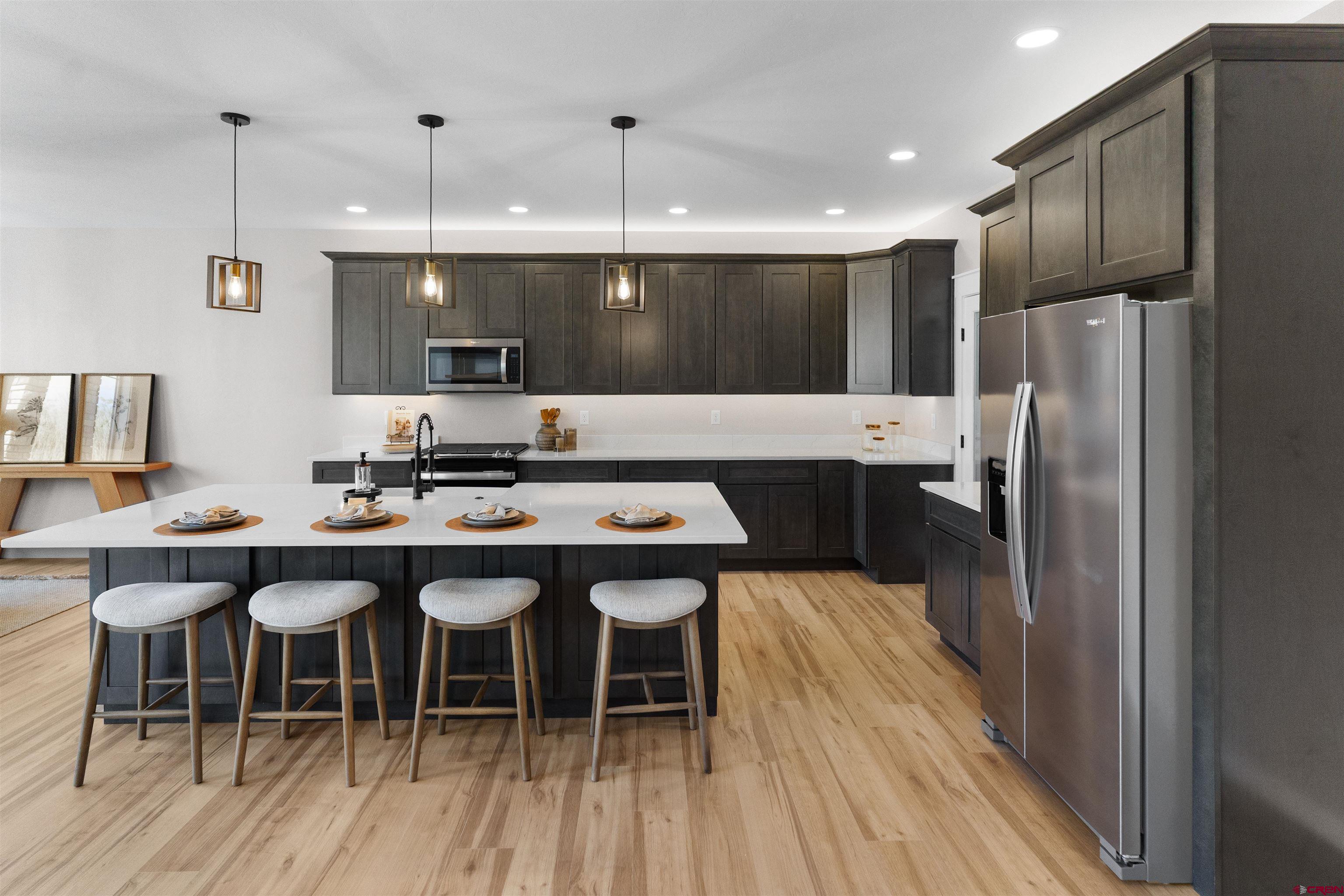 1539 Criterion Street Delta, CO 81416 - Photo 35 of 41 a kitchen with a table chairs refrigerator and cabinets