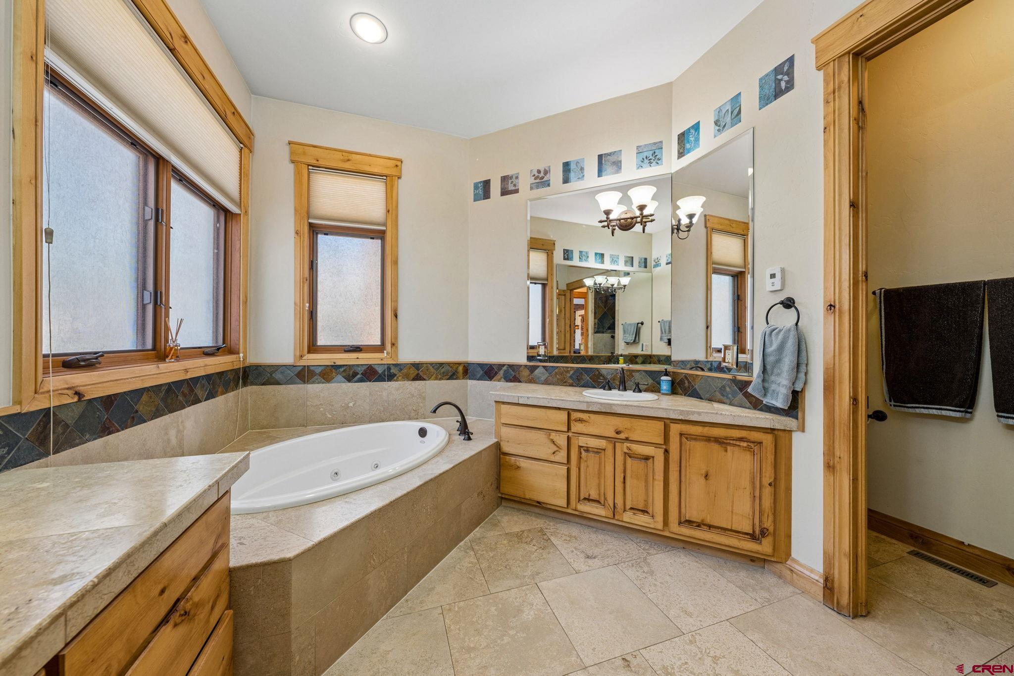 70 Clear Creek Loop Durango, CO 81301 - Photo 16 of 35 a bathroom with a granite countertop tub sink and mirror