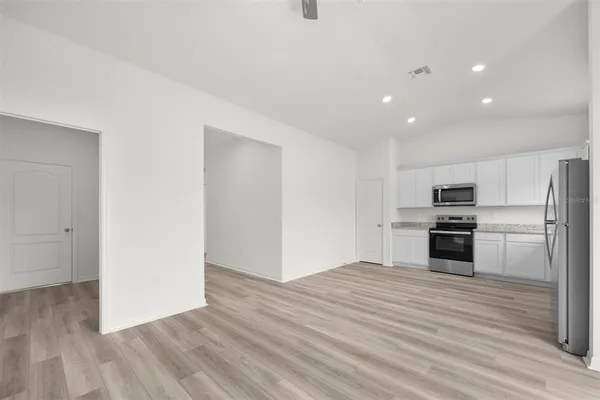 a kitchen with granite countertop a refrigerator and a stove top oven