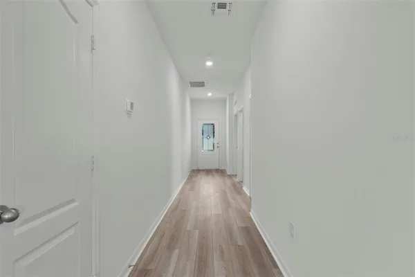 a view of a hallway with wooden floor