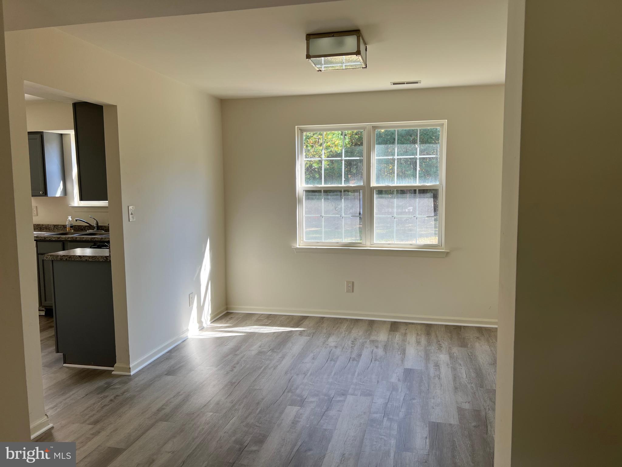 560 South Pitney Road Galloway Township, NJ 08205 - Photo 6 of 34 an empty room with wooden floor cabinet and windows