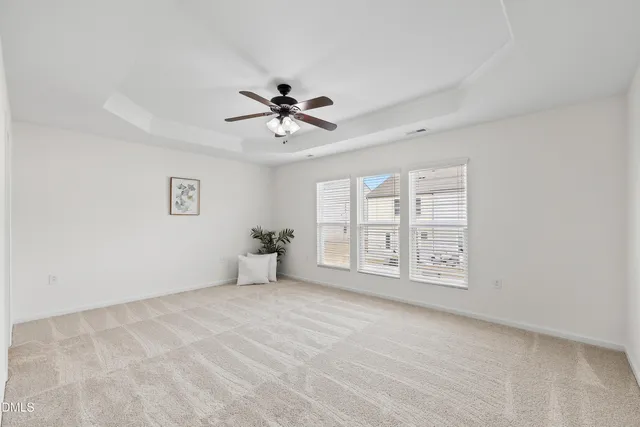 a view of a livingroom with a ceiling fan wooden floor and kitchen