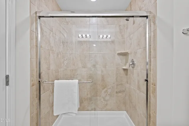 a view of a big room with a chandelier fan and windows