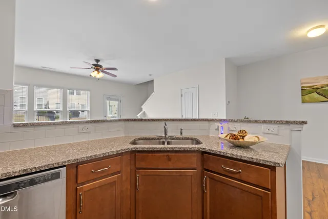 a kitchen with stainless steel appliances granite countertop a sink stove and microwave with wooden cabinets