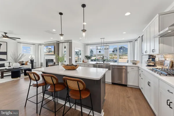 a kitchen with stainless steel appliances kitchen island granite countertop a sink a stove a dining table and chairs