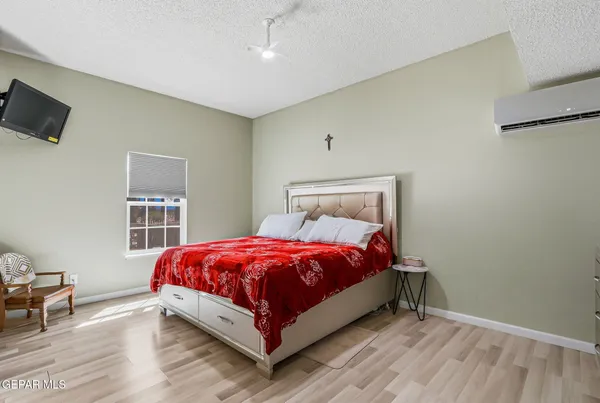 a bed sitting in a bedroom next to a window and a flat screen tv