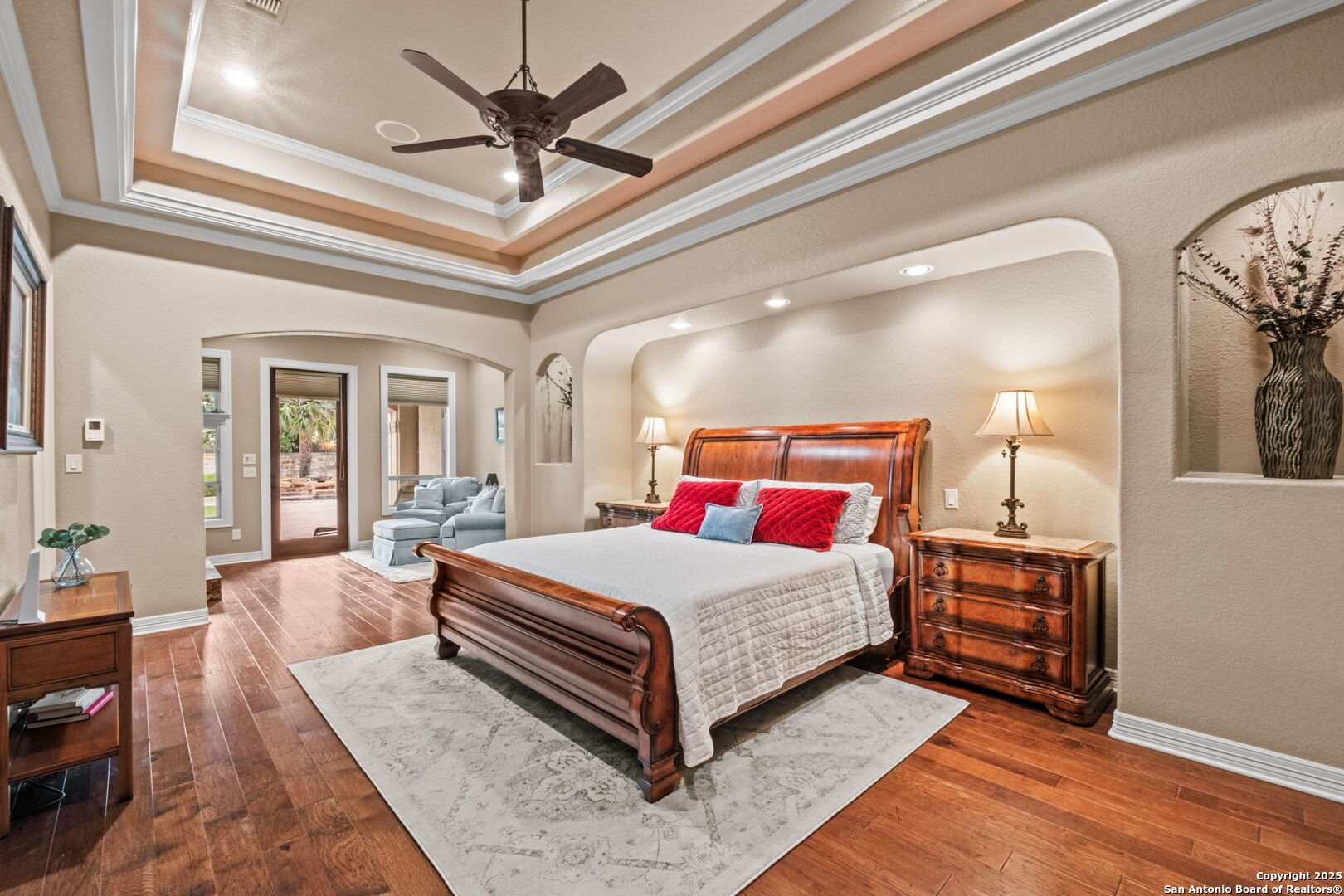 208 Cascade Caverns Road Boerne, TX 78015 - Photo 58 of 74 a bedroom with a large bed and a chandelier