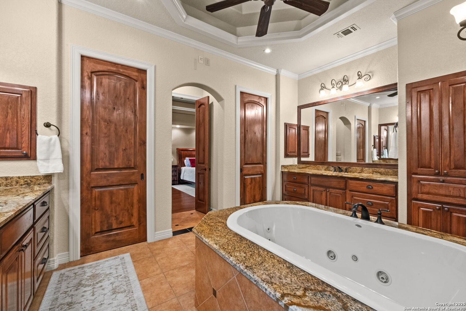 208 Cascade Caverns Road Boerne, TX 78015 - Photo 63 of 74 a bathroom with a tub a double vanity sink and a mirror