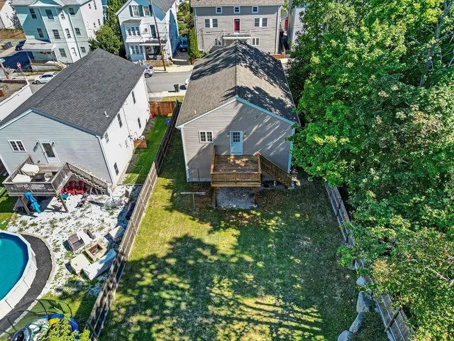 an aerial view of a house with swimming pool and garden