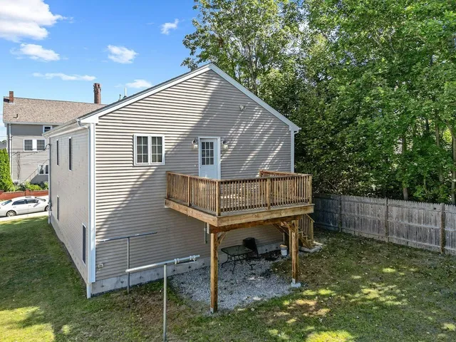 a view of a small house with a yard balcony and furniture