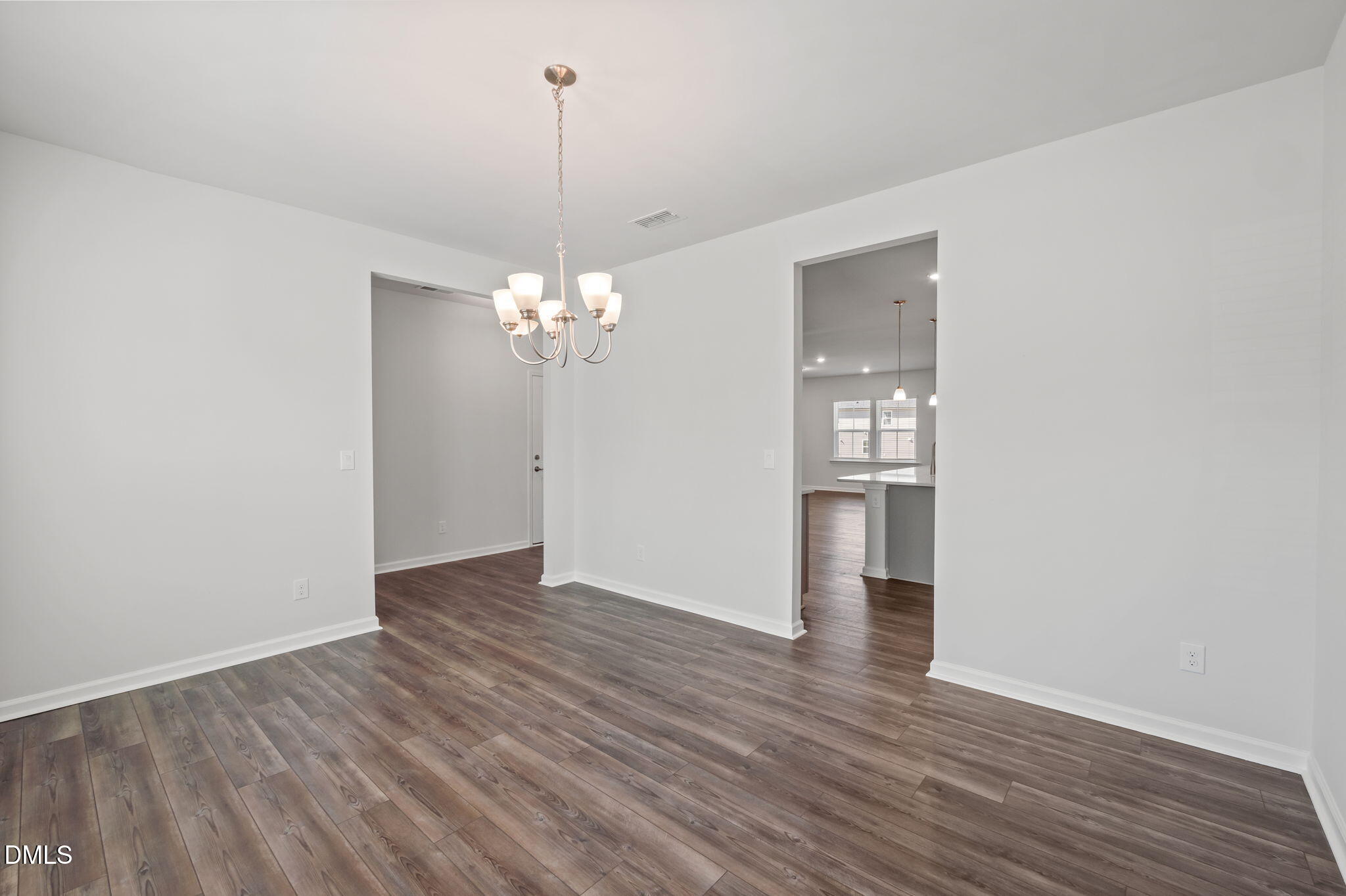 701 Mayfly Way Durham, NC 27703 - Photo 7 of 50 a view of an empty room with wooden floor and kitchen view