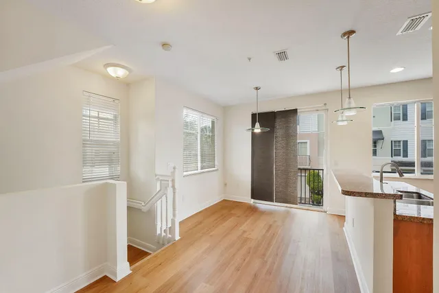 an empty room with wooden floor and ceiling fan