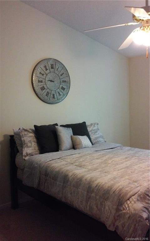 8445 Angwin Place Charlotte, NC 28262 - Photo 9 of 20 a bedroom with a bed and a lamp on the dresser