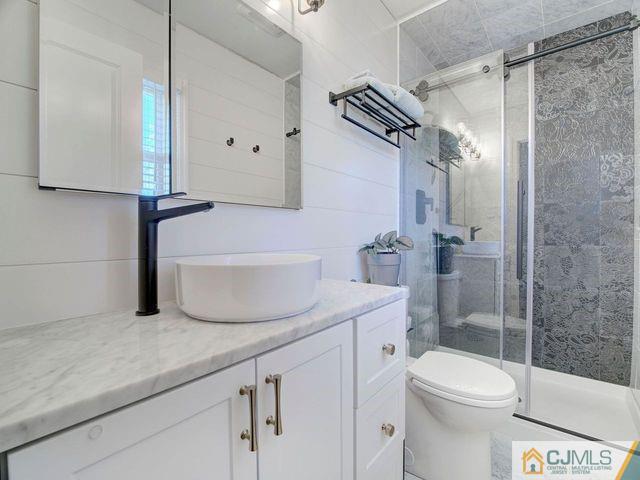 33 Thomas Road East Brunswick, NJ 08816 - Photo 17 of 28 a bathroom with a granite countertop sink toilet and shower