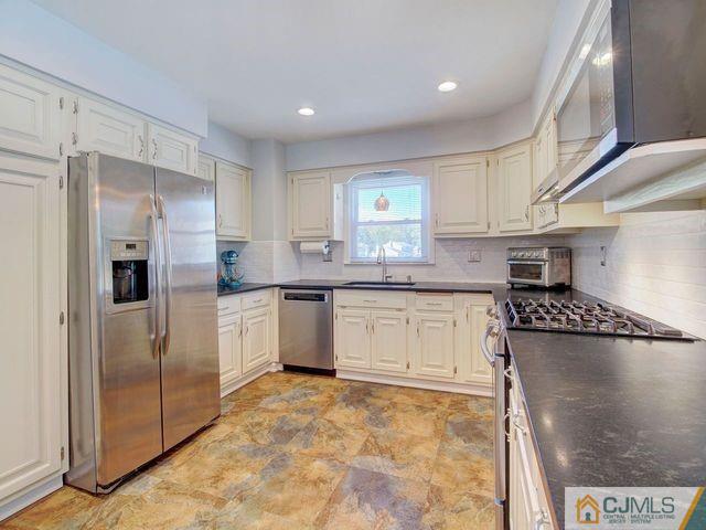 33 Thomas Road East Brunswick, NJ 08816 - Photo 9 of 28 a kitchen with stainless steel appliances granite countertop a refrigerator and a stove