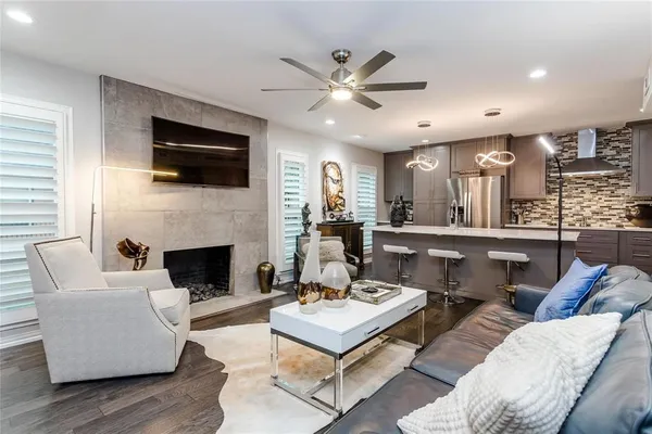 a living room with furniture a flat screen tv and kitchen view