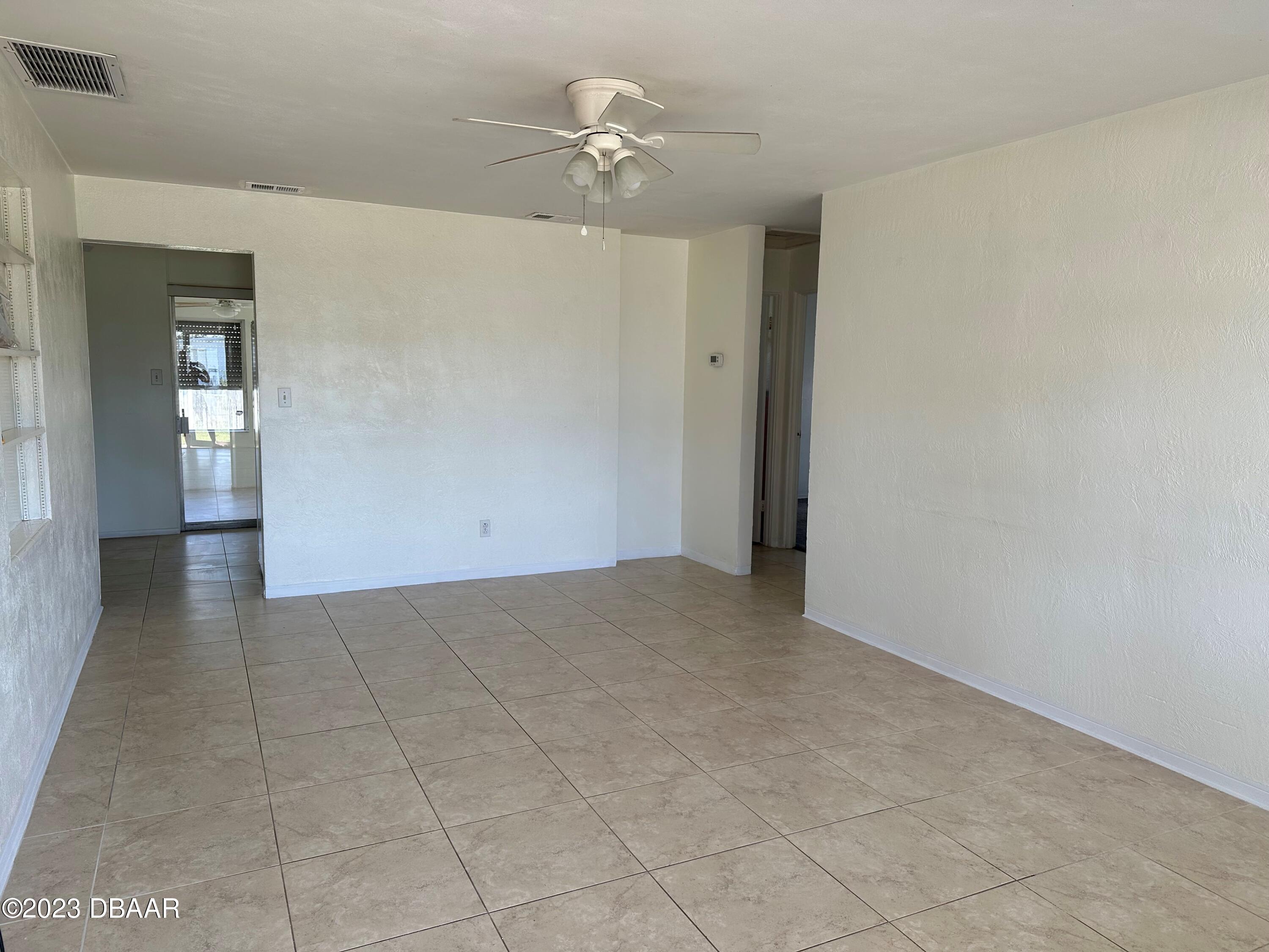 38 Carol Road Ormond Beach, FL 32176 - Photo 3 of 16 a view of an empty room with a ceiling fan