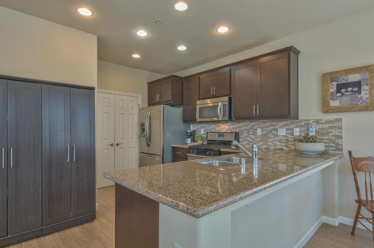 1805 Monte Bella Boulevard Salinas, CA 93905 - Photo 12 of 32 a kitchen with stainless steel appliances granite countertop a sink refrigerator and microwave