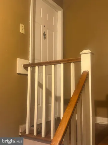 a view of staircase with railing and white walls