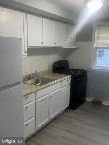 a kitchen with white cabinets and a sink