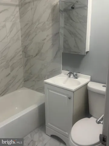 a white toilet sitting next to a white bath tub