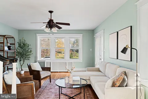 a living room with furniture a chandelier and a window