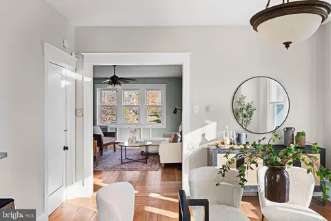 a living room with furniture a mirror and a view of bathroom