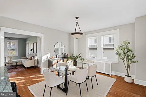 a living room with furniture a chandelier and wooden floor