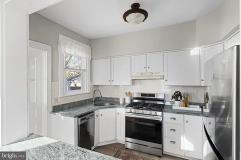 a kitchen with stainless steel appliances granite countertop a stove a sink and a refrigerator