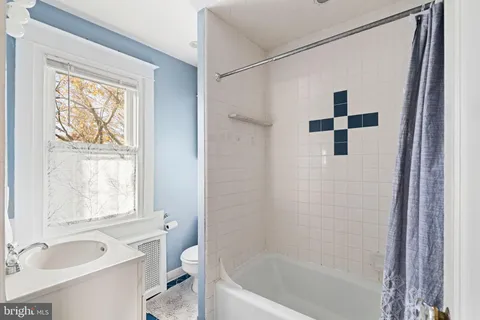 a bathroom with a toilet a sink and mirror