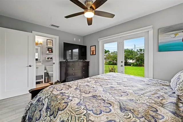a bed in a bedroom next to a window with a flat screen tv