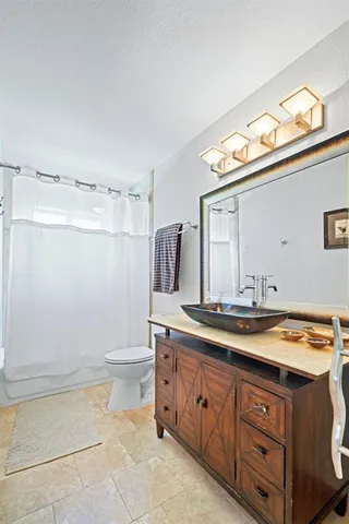 a bathroom with a granite countertop sink a toilet and a mirror