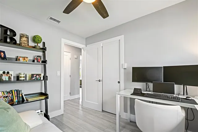 a view of a workspace with furniture and wooden floor