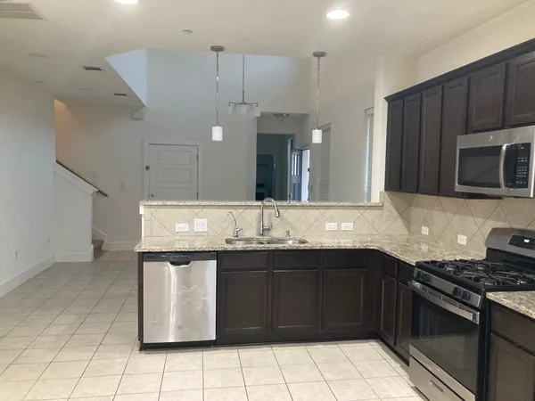 a kitchen with granite countertop wooden cabinets and stainless steel appliances