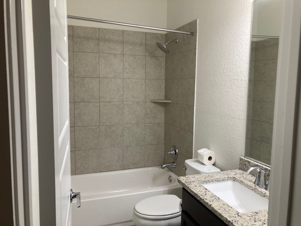 12410 Maypole Bend, Unit 1401 Austin, TX 78717 - Photo 27 of 32 a bathroom with a granite countertop bathtub shower sink vanity and toilet
