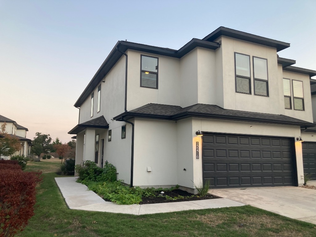 12410 Maypole Bend, Unit 1401 Austin, TX 78717 - Photo 4 of 32 a front view of a house with a yard and garage