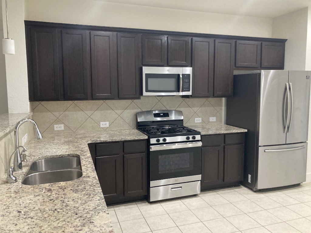 12410 Maypole Bend, Unit 1401 Austin, TX 78717 - Photo 9 of 32 a kitchen with stainless steel appliances granite countertop a refrigerator stove a sink and dishwasher