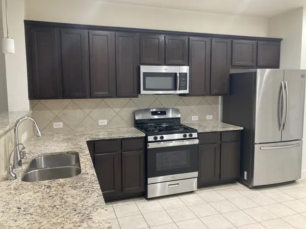 a kitchen with stainless steel appliances granite countertop a refrigerator stove a sink and dishwasher