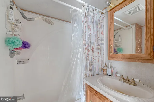 a bathroom with a granite countertop sink a mirror and a shower